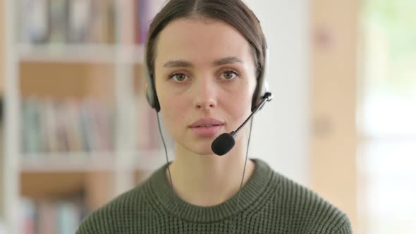 Call Center Young Woman with Headset Looking at the Camera