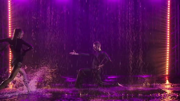 Jive Elements Performed By a Passionate Couple in the Rain. Photographed in a Dark Studio Against a