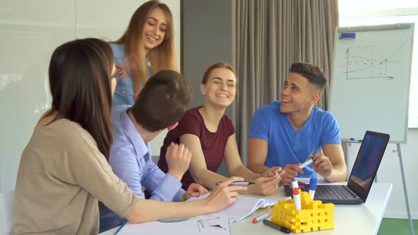 Young People Discuss Something on Laptop at the Office