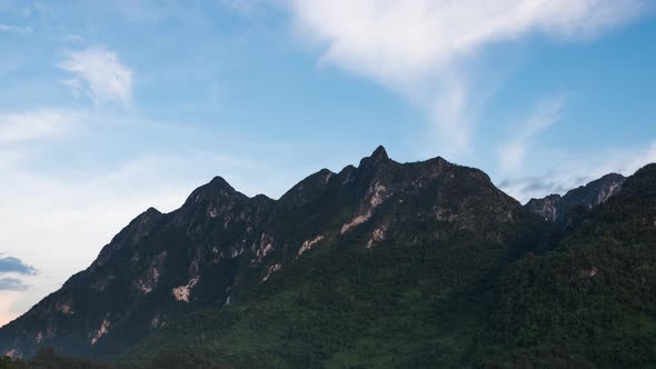 Beautiful timelapse scenery of tropical mountain range with clouds and blue sky in the morning