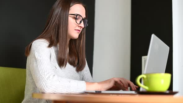 A Young Woman with a Laptop in the Cafe