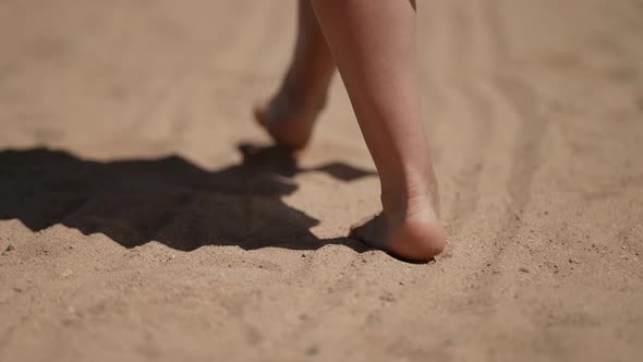 Bare Feet Walk on the Sand on a Sunny Day