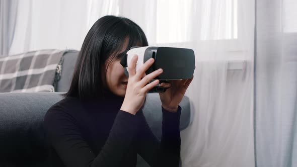 Young Asian Woman Putting on VR Googles