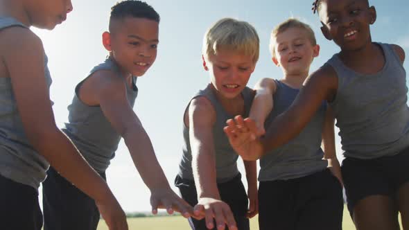 Video of happy diverse boys team clapping hands outdoors