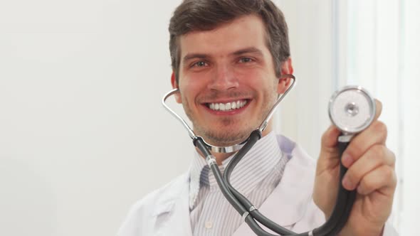 Cute Doctor Is Pointing at Camera His Stethoscope