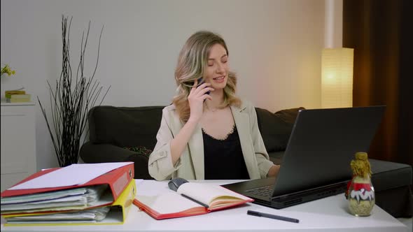 Young Caucasian woman discussing financial document with colleagues via phone call