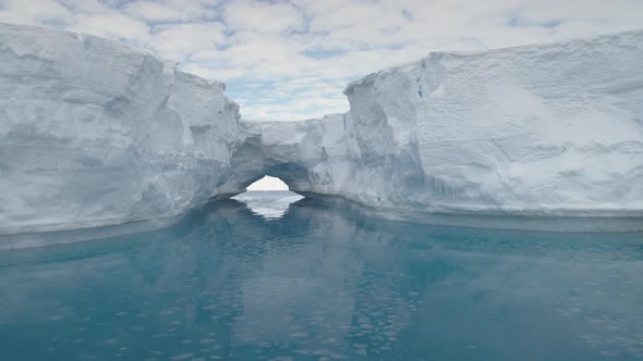 Antarctica Icebergs with Arch Reflected in Ocean.
