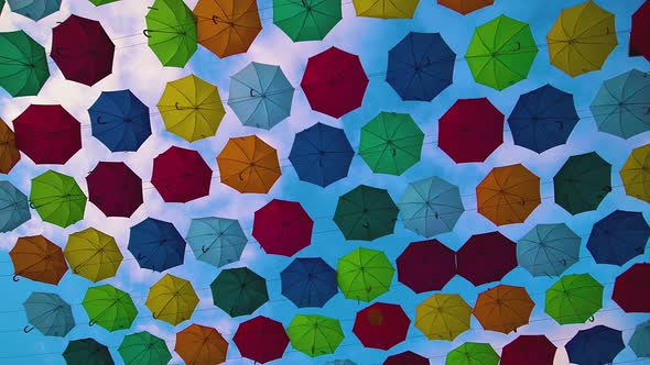 Flying Umbrellas. Multi Colored Parasol Soar in the Sky. Umbrellas Suspended Above Their Heads