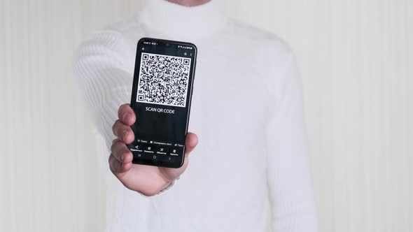 Male Hand Shows QR Code on Smartphone on White Background
