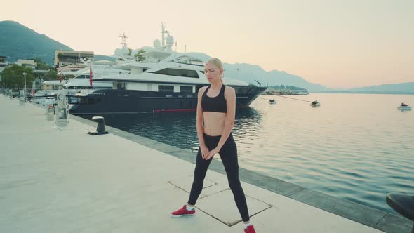 Motivated Woman Making Stretches Outside in City Quay