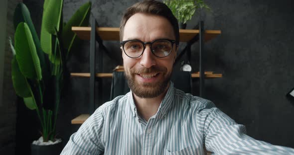 POV of Handsome Business Man Making Selfie Video Call While Sitting at Modern Office