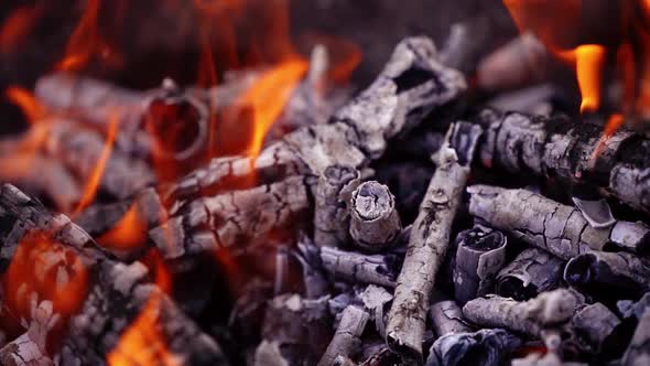 Slow motion pull out clip of a large bonfire burning brightly at night.