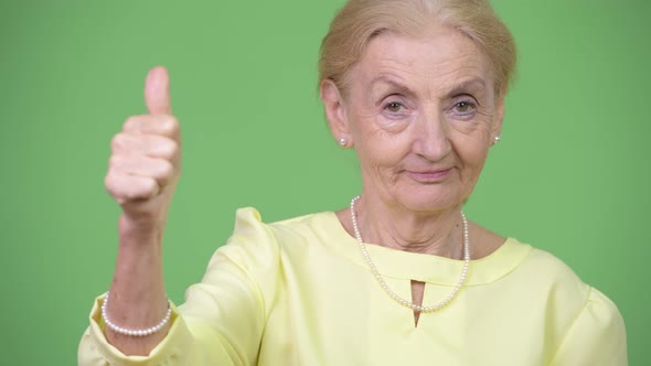 Happy Senior Businesswoman Giving Thumbs Up