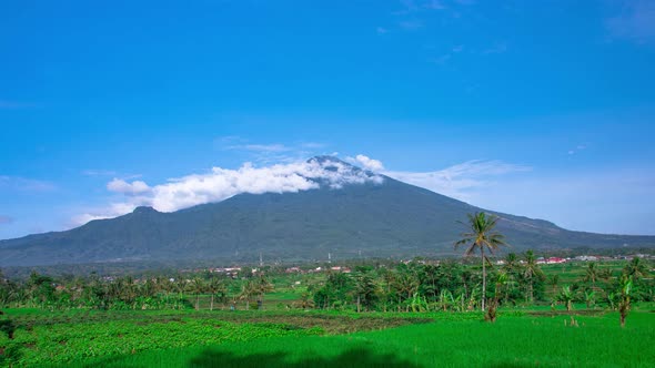 Beautiful Ciremai mountain against a backdrop of blue sky and green rice fields