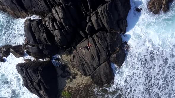 Long Haired Girl Meditates in Yoga Pose on Large Grey Rock