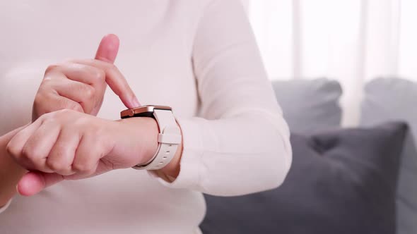 Technology online IOT concept. Close up shot of a woman hand who touch and scrolling on a smartwatch