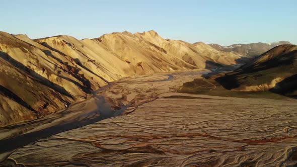 Spacious valley with curvy rivers near rough hills