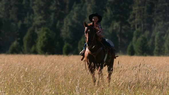 Young cowboy riding horse, slow motion