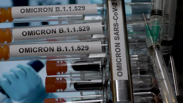 Test tubes marked with Omicron label for sample collection and testing, extracted from stand. vertic