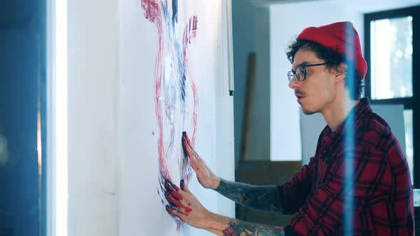 Young Man Is Painting a Picture with His Hands