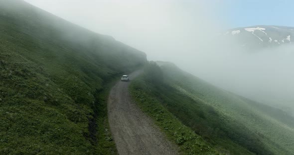 AERIAL - Car driving down the Tskhratskaro Pass, Georgia, rising forward shot