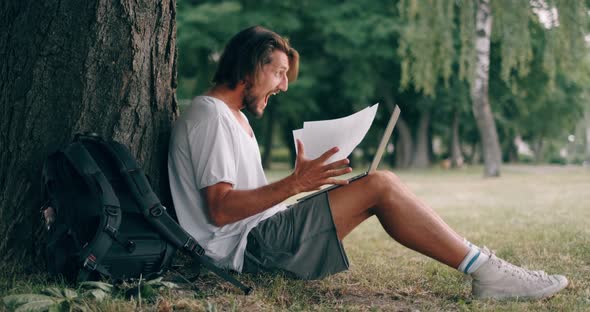 Happy Bearded Man Enjoy Good Results on Laptop Computer at the Park. Shocked Man Celebrating