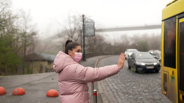 Young Woman Standing on Road Outdoors Raising Hand Aside Catching Taxi