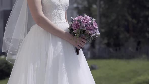 Slow Motion Bride Figure in Dress with Purple Bouquet