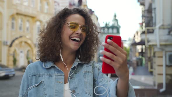 Young Beautiful Latin Girl Laughing While Making a Video Call on Her Smartphone