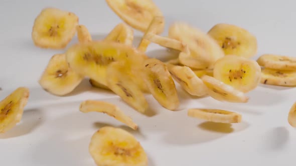 Banana Chips falling onto a white surface in slow motion