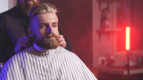 Male Barber Preparing Client for Cutting Beard