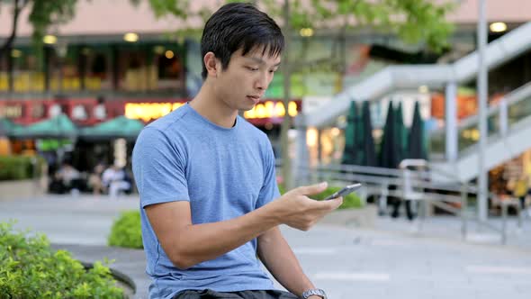 Young Man using cellphone in city 