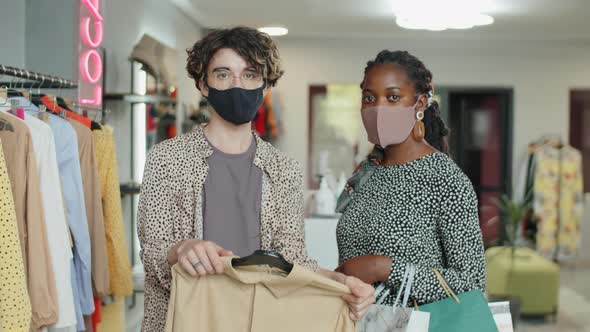 Portrait of Multiethnic Masked Man and Woman in Clothes Shop