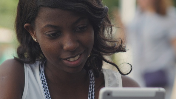 Stylish black female woman working with modern tablet outdoor