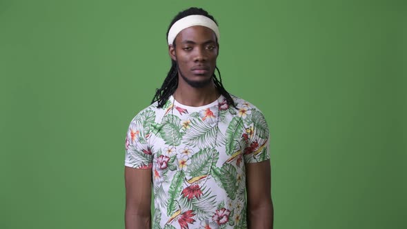 Young Handsome African Man with Dreadlocks Against Green Background