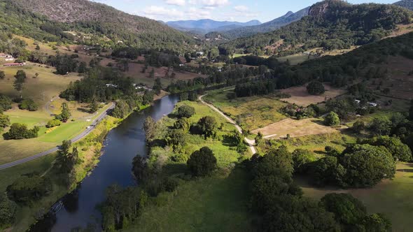 A high view drone video flying along a small river through a scenic valley close to the popular Moun