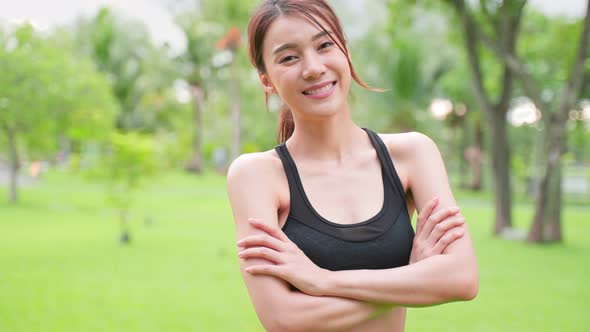 Portrait of young girl in sportswear smile, and look at camera after running workout at public park.