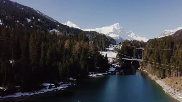 This shot was taken in the Swiss alps. The lake is surrounded by trees and a road.