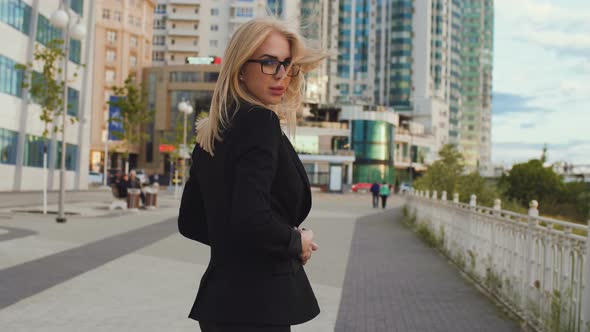 Beautiful Business Woman Blond In Glasses Walks Street Of The City