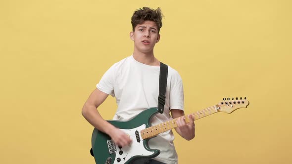 Portrait of Teen Player in Casual Playing Solo on Electric Guitar and Singing Emotionally Isolated