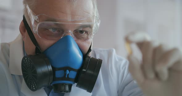 Extreme Close-up of a Scientist in a Blue Respirator and Protective Glasses Who Developed a