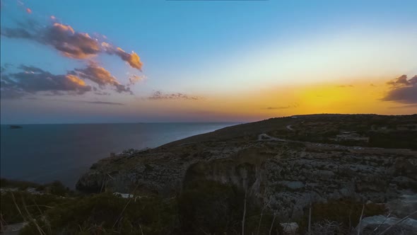 Golden hour sunset over ocean from Blue Grotto, Malta, time-lapse