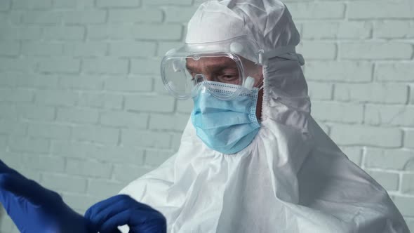 Man Doctor Wearing Medical Latex Gloves To Fight Coronavirus Pandemic Covid-2019. Protective Suit