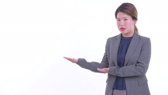 Stressed Young Asian Businesswoman Talking While Showing Something