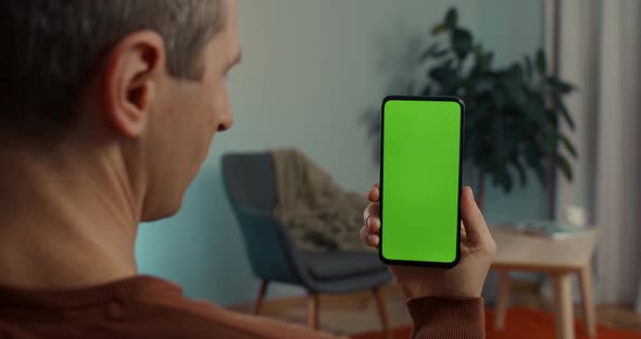 Man Holding Modern Smartphone with Chroma Key Screen