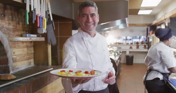 Caucasian chef showing his dish