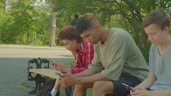 Diverse Multiethnic Young People Networking Online on Smartphones Outdoors