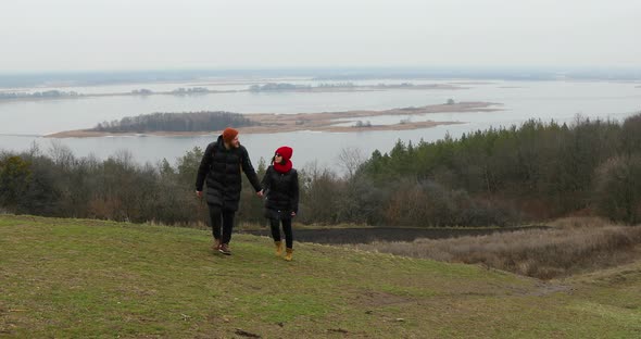 Couple travelers holding hands walk and view on landscape river