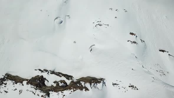 Aerial drone view of snow covered mountains in the winter.