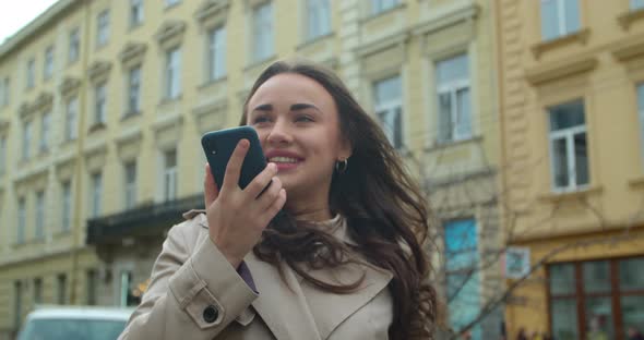 Woman Using a Smartphone Voice Recording Function Online in the City Street, Talking To Mobile